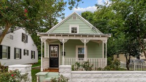 A small, single-story house with a porch and a white picket fence. - The Cottage in Little Washington (Washington)
