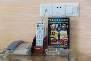 Ein Telefon, eine Steckdose und ein Poster mit Essensbildern.