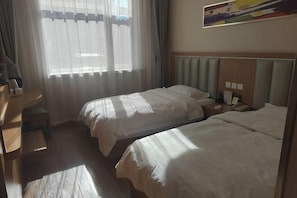 A hotel room with two beds, a desk, and a window with sheer curtains. - Jinshan Hotel (Harqin Banner)