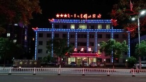 A hotel with a traditional architectural style, featuring a prominent entrance with illuminated signage. - Jinshan Hotel (Harqin Banner)
