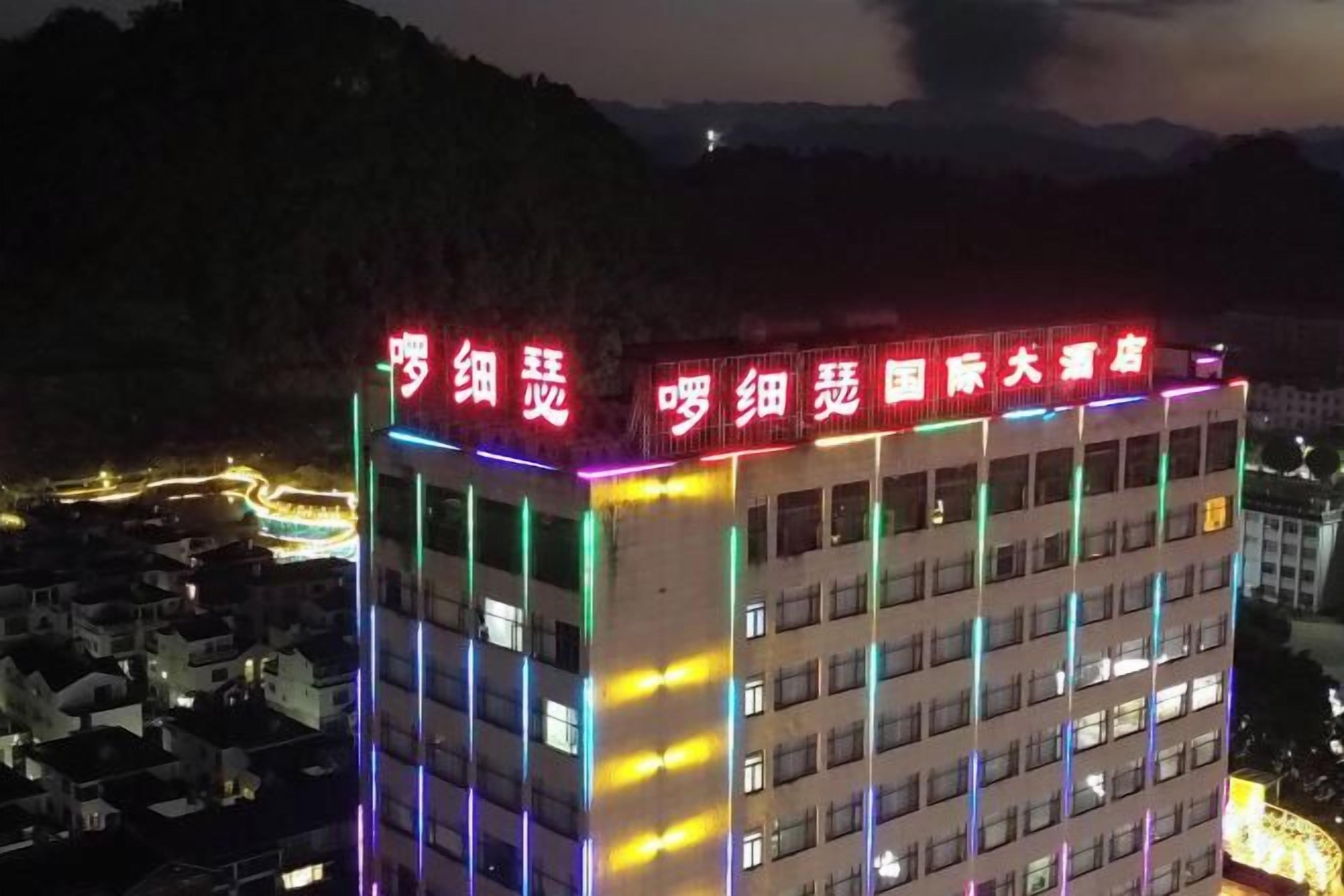 A multi-story building with illuminated signage and windows.