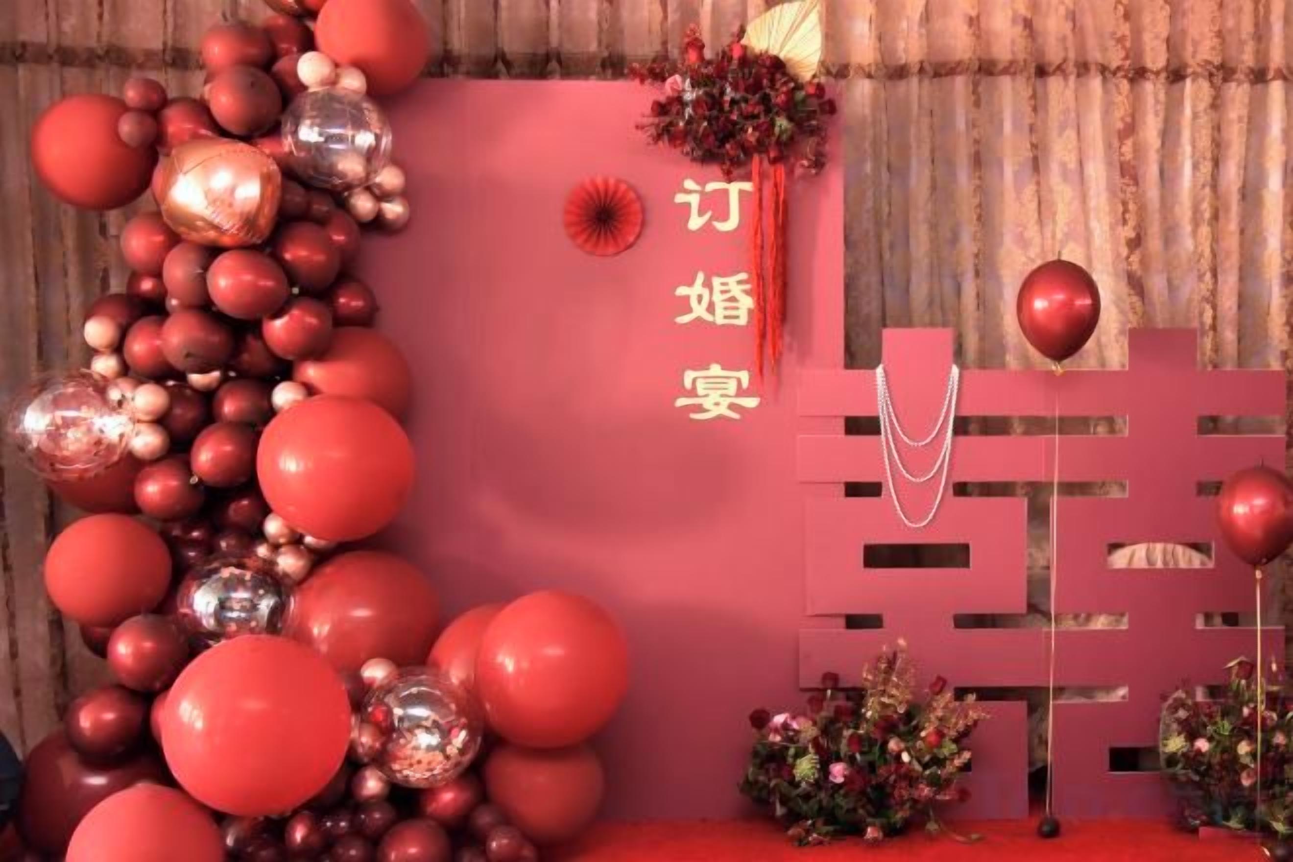 A red-themed decoration with a vertical arrangement of balloons and a decorative wall.