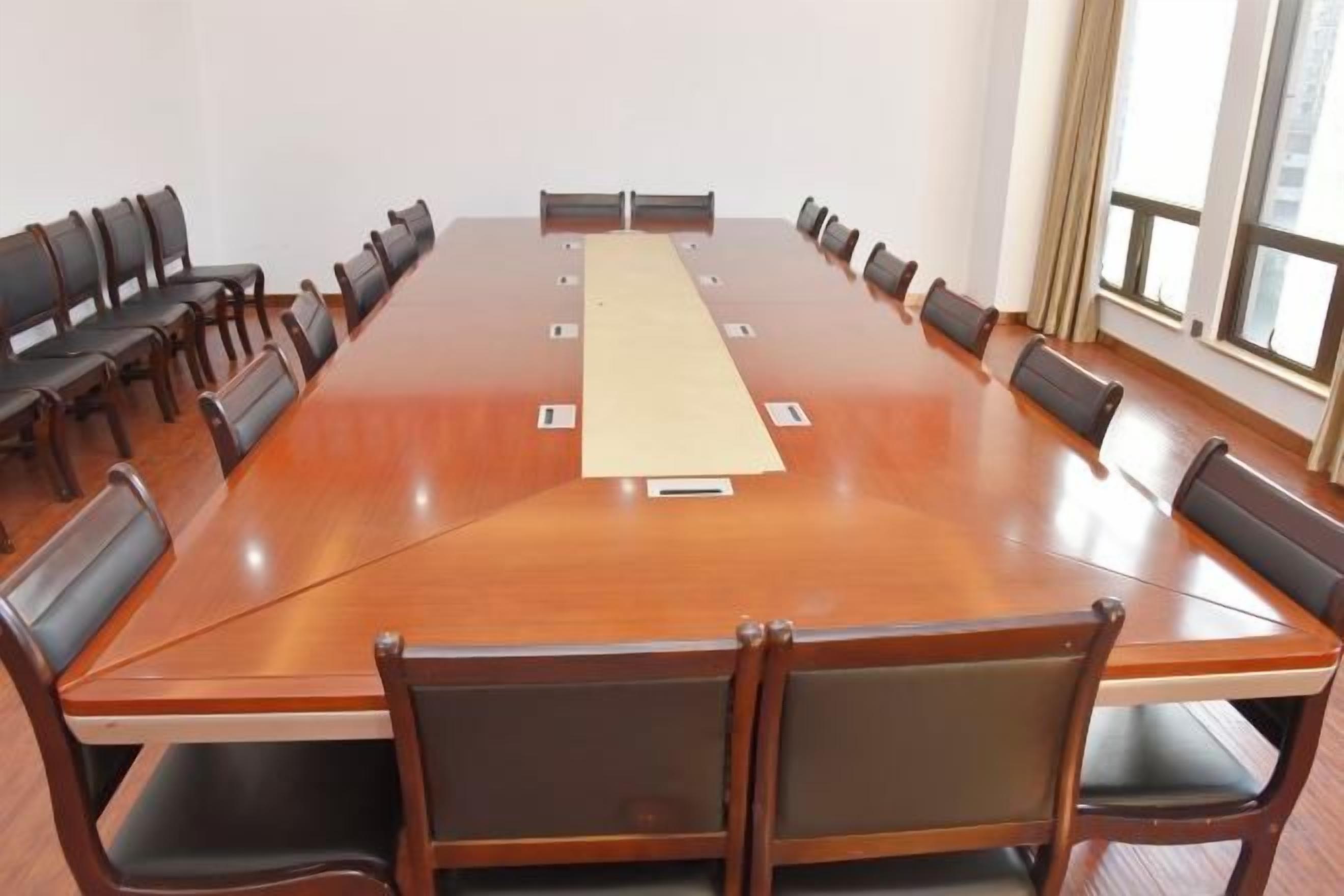A conference room with a long table, chairs, and a projector.