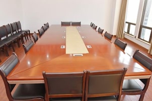 A conference room with a long table, chairs, and a projector.