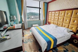 A hotel room with a bed, a desk, a chair, a window with curtains, and a view of a cityscape. - Zhenkang Loisse International Hotel (Zhenkang)