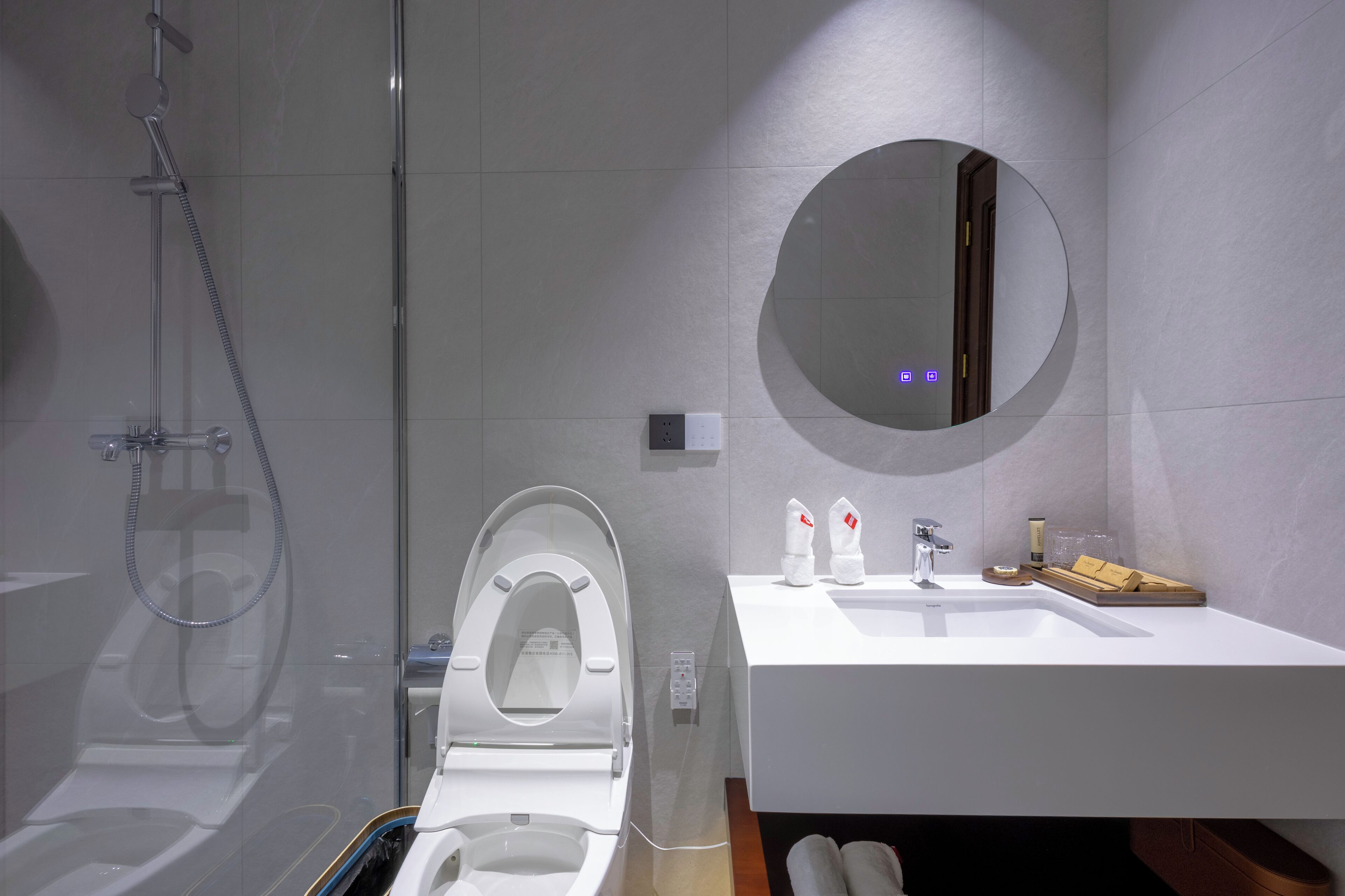 A modern bathroom with a toilet, shower, and sink.