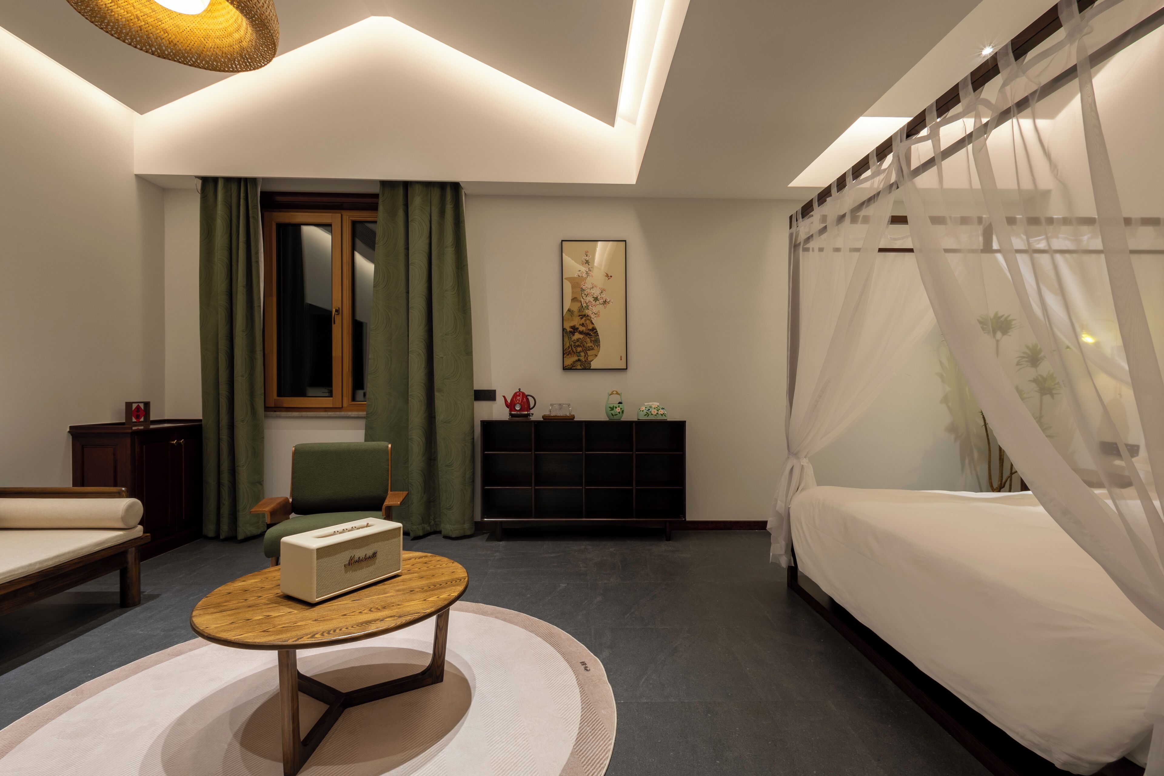 Ein modernes Hotelzimmer mit Bett, einer Sitzecke, einem kleinen Tisch und einem Schrank.