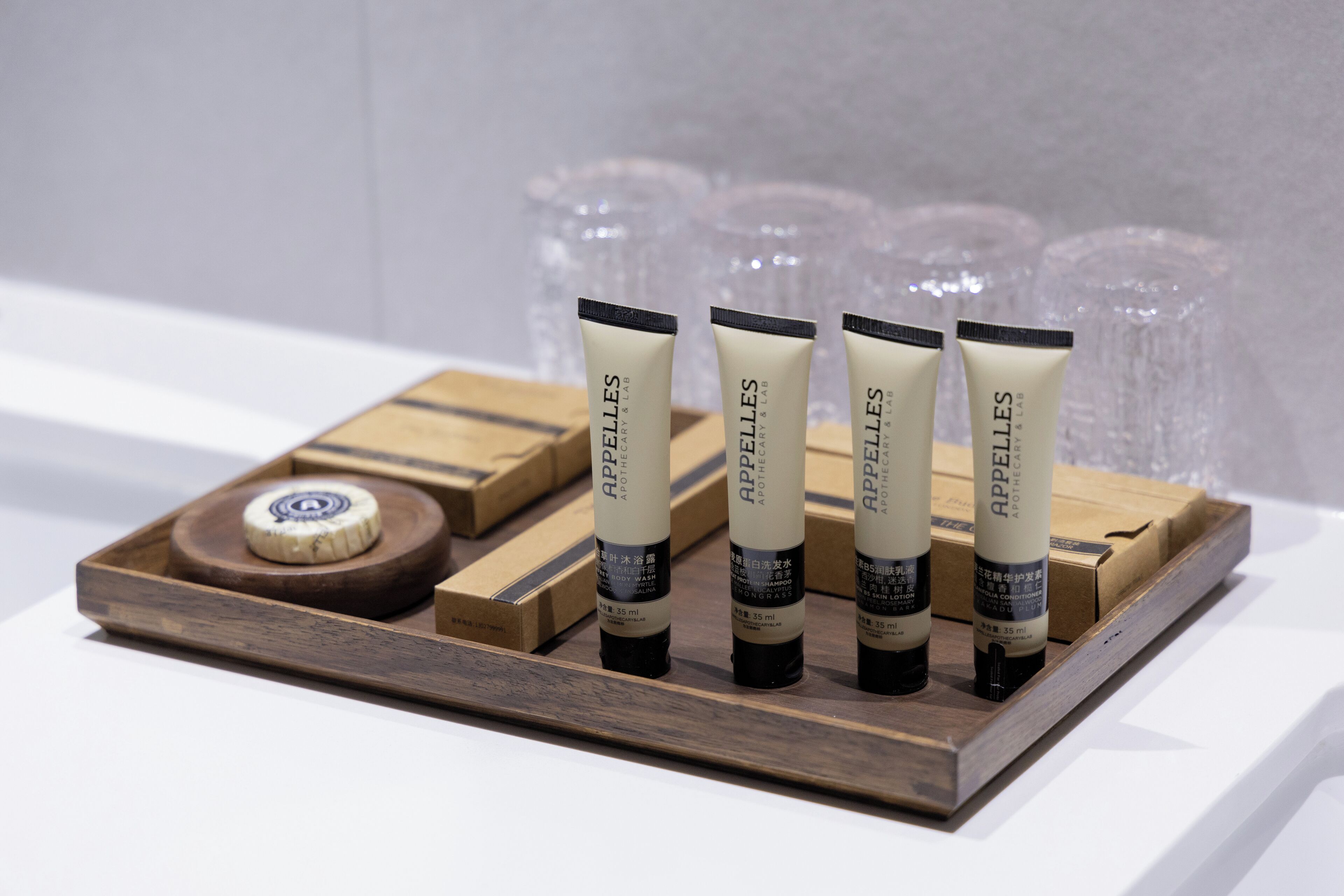 A wooden tray with five tubes of 'Appelles' skincare products and a round soap bar.