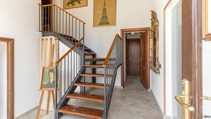 A staircase with wooden steps and black railings, leading to a door with a golden handle.
