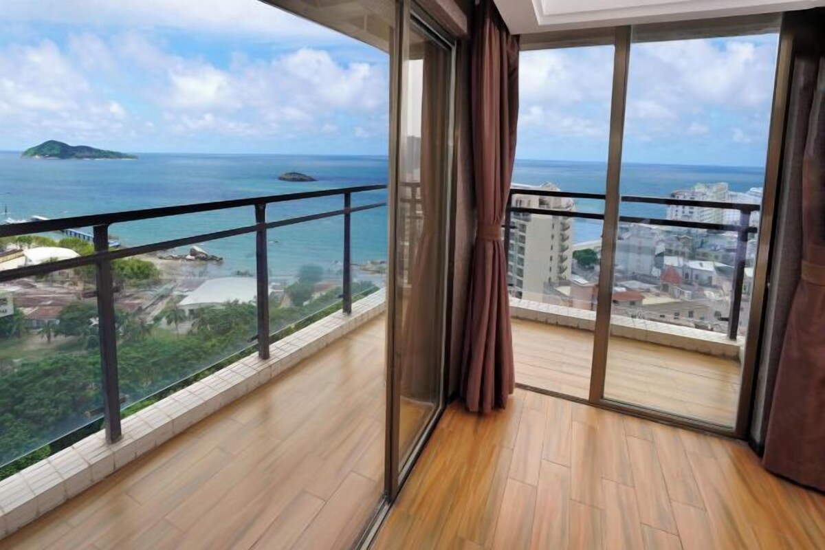 A balcony with a view of the sea and a distant island.