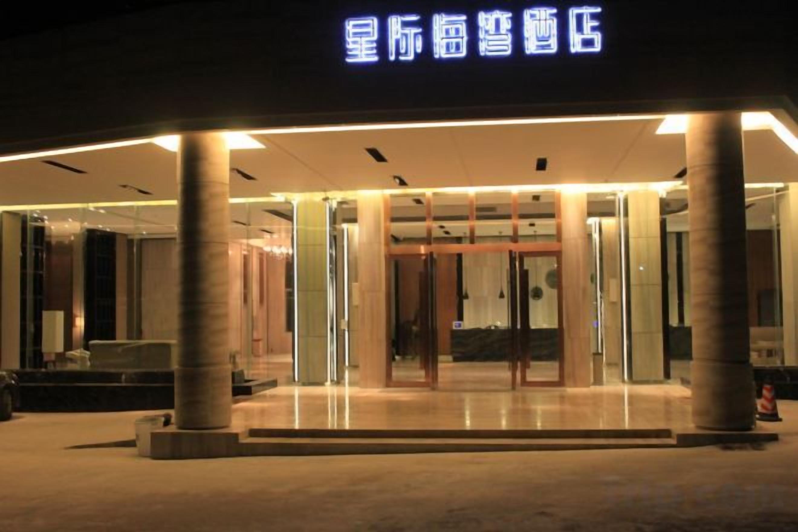 A hotel entrance with a modern design, featuring a glass facade and a prominent entrance.