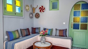 A room with a sofa set, a small table, and a decorative vase. - Cozy Ensuite Room with AC

 (Tangier)