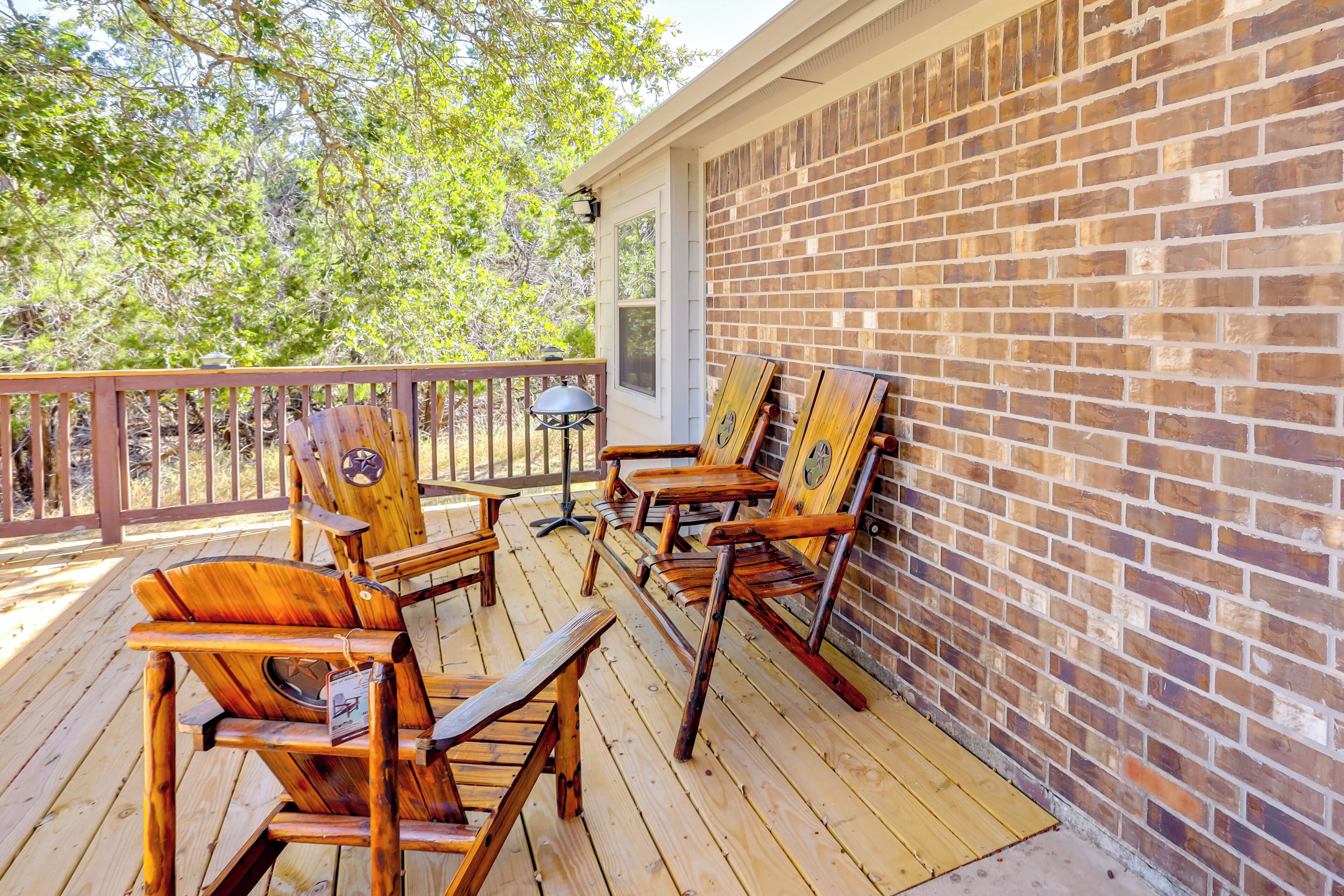 A wooden deck with outdoor seating and a brick wall.