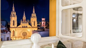 A room with a view of a cathedral, a white lamp, and patterned cushions. - Solaga - Sagrado Corazon (Málaga)