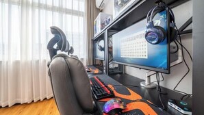 Uma estação de jogos com cadeira, dois monitores, teclado, fones de ouvido e mouse.