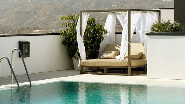 A rooftop pool with a lounge area, a view of mountains, and a clear sky. - Flat like in a skyscraper in Manhattan , but with views of old Malaga Urban Sky (Malaga)
