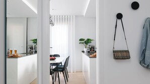 A modern kitchen with a dining area, wooden flooring, and a mirror reflecting the space. - Flat like in a skyscraper in Manhattan , but with views of old Malaga Urban Sky (Malaga)