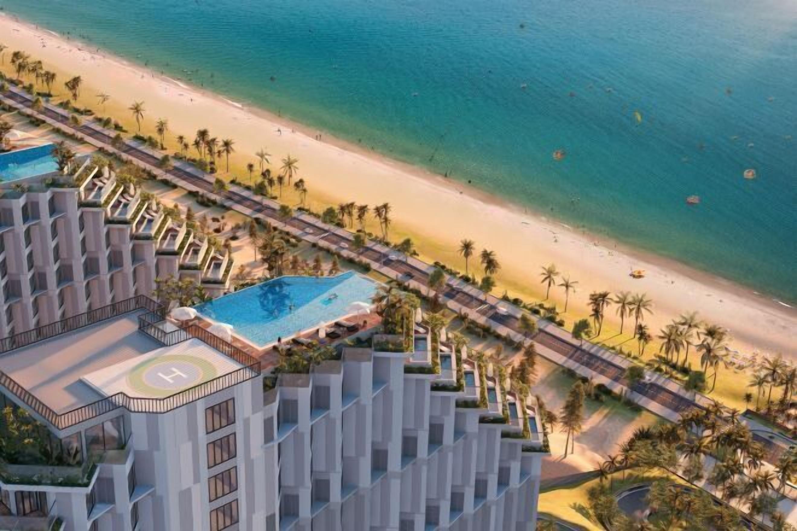 Un resort con piscina, playa y palmeras.