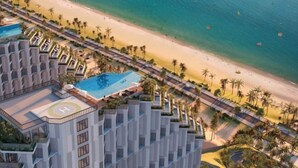 A resort with a pool, beach, and palm trees. - Mandala Cham Bay Mui Ne (Phan Thiet)