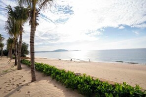 A beach with palm trees, a sandy path, and a view of the sea. - Mandala Cham Bay Mui Ne (Phan Thiet)