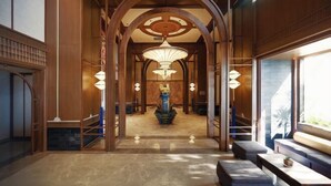A hallway with wooden arches, a central decorative sculpture, and seating areas. - Mandala Cham Bay Mui Ne (Phan Thiet)