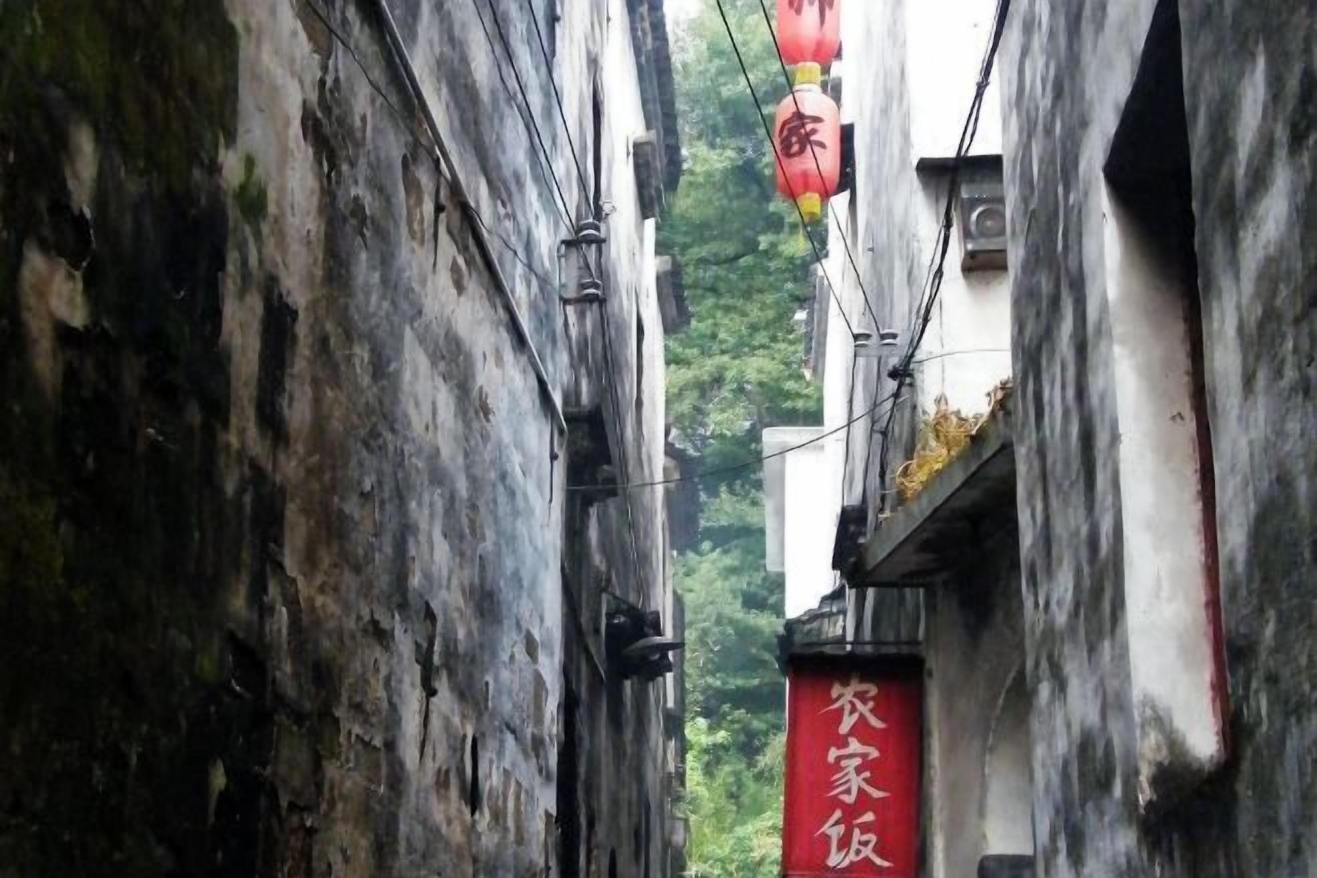 A narrow alleyway with a red sign on the right side.