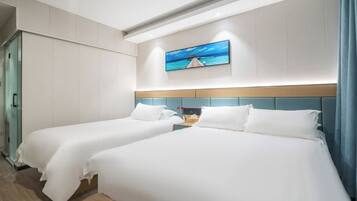 A hotel room with two beds, a painting on the wall, and a wardrobe.