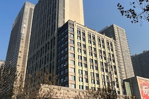 Um edifício alto com uma grade de janelas e uma estrutura vertical central.