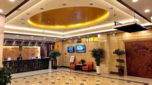 A hotel lobby with a reception desk, seating area, and a large decorative ceiling. - Jinheyuan International Hotel Guide (Guide)