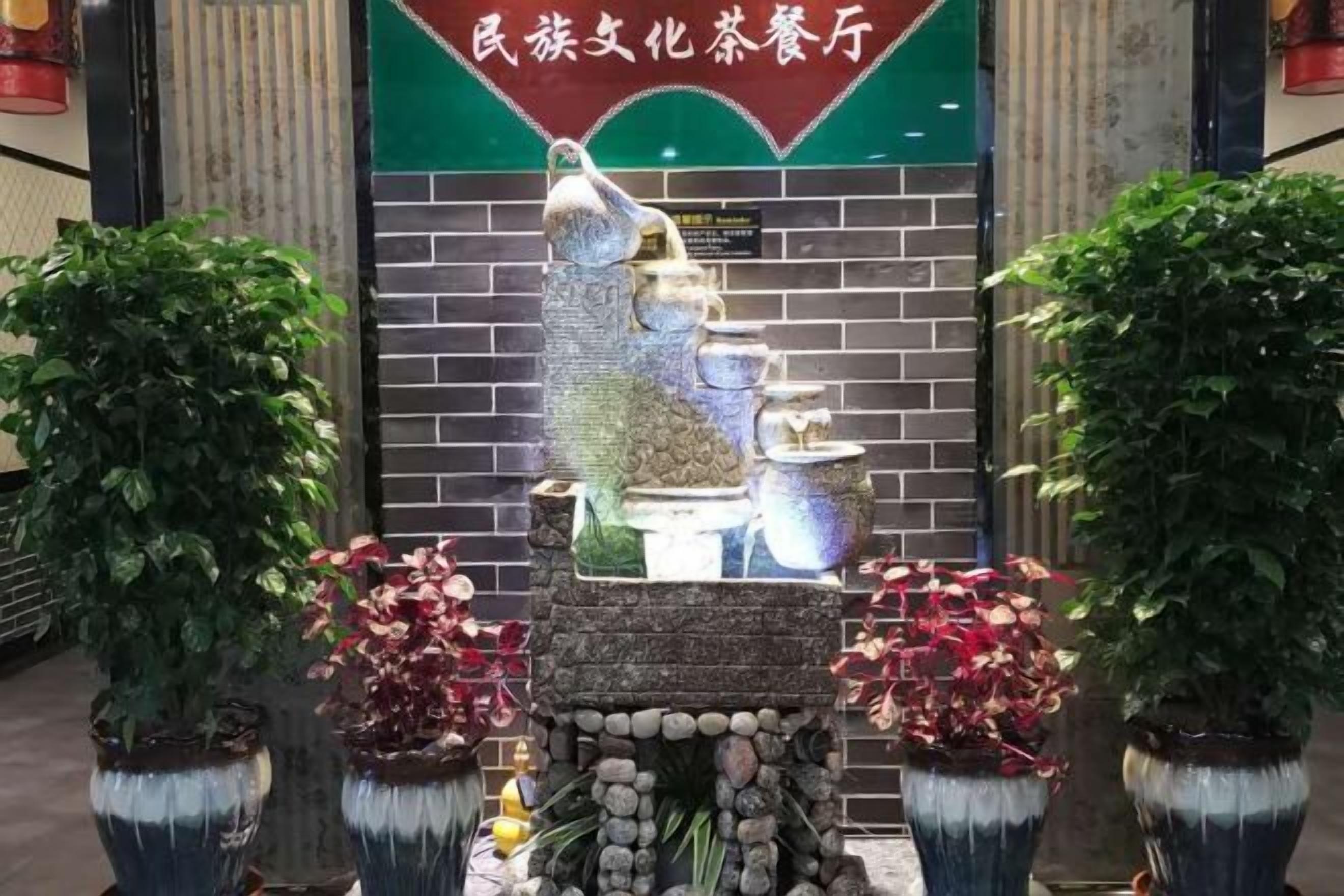 A traditional Chinese tea ceremony setup with stone sculptures and potted plants.