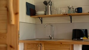 A kitchen with a wooden countertop, a stainless steel sink, and a coffee maker.