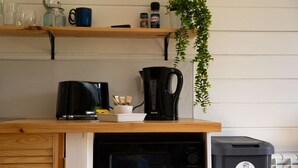 A kitchen with a coffee maker, kettle, and a plant on a shelf. - Aonach Mor Pod near Fort William (Caol)