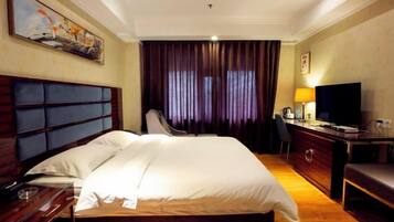 A hotel room with a large bed, a desk with a chair, a television, and a painting on the wall.