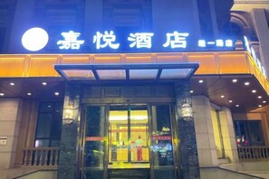 Entrada de un hotel, con un letrero que indica que es el 'Joy Hotel'.