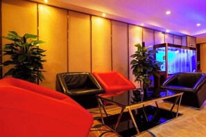 Un hall d’hôtel comprenant des espaces d’attente, un comptoir d’accueil et un mur décoratif.