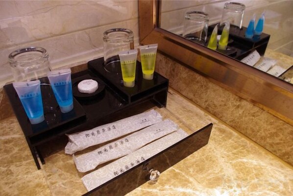 A bathroom vanity with toiletries, a mirror, and a towel rack. - Sunshine Business Hotel (Zhengzhou)