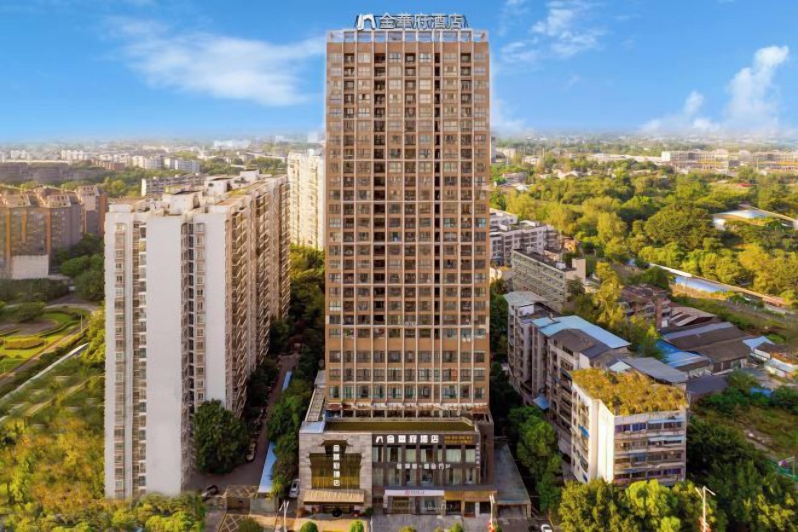 Un edificio de gran altura con varios pisos, rodeado de otros edificios residenciales y vegetación.