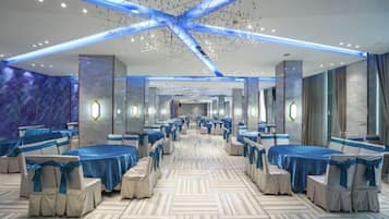 Comedor de hotel con mesas redondas, sillas y piso con diseño.