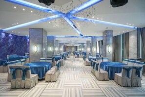 A hotel dining area with round tables, chairs, and a patterned floor. - Jinhuafu Hotel (Longchang)