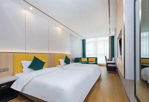 A hotel room with a large bed, a desk, and a seating area. - Jinhuafu Hotel (Longchang)