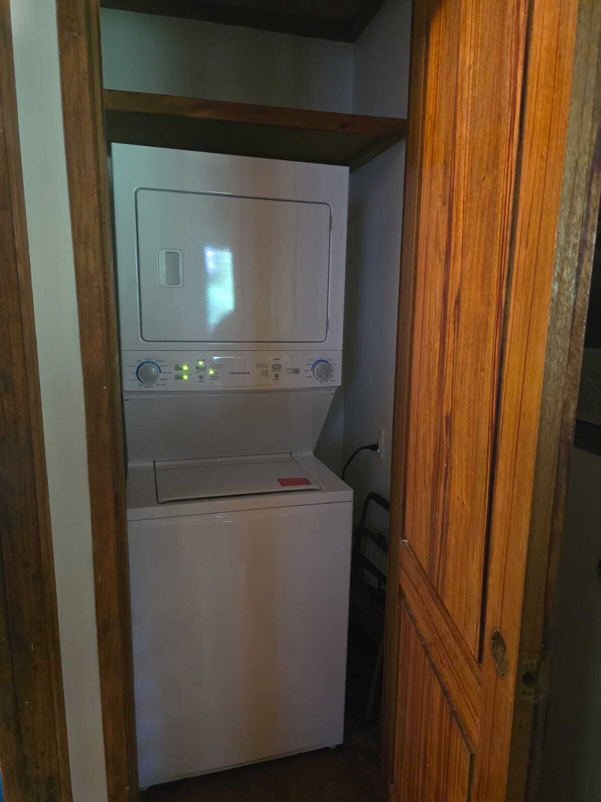 Een kleine wasruimte met een wasmachine en droger.