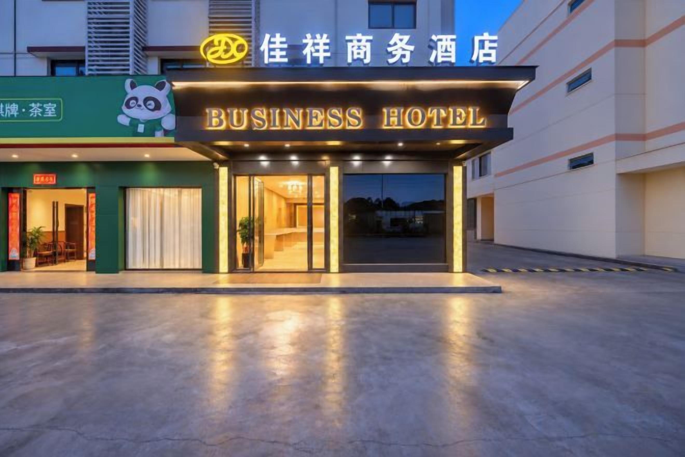 A business hotel with a prominent entrance, a panda logo, and a sign indicating a restaurant.