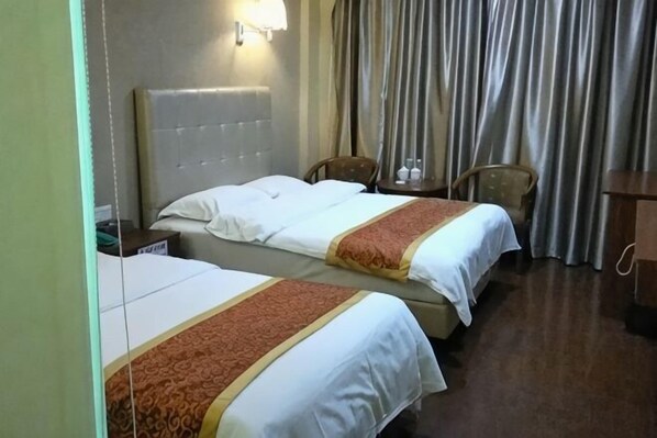 A hotel room with two beds, a headboard, a nightstand, a chair, a table, and curtains. - Jiaxiang Business Hotel (Zhongshan)