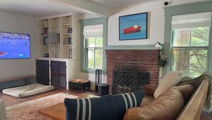 Ein Wohnzimmer mit Kamin, Fernseher und Bücherregal.