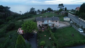 Une maison avec un patio, une pelouse et une vue sur la mer.