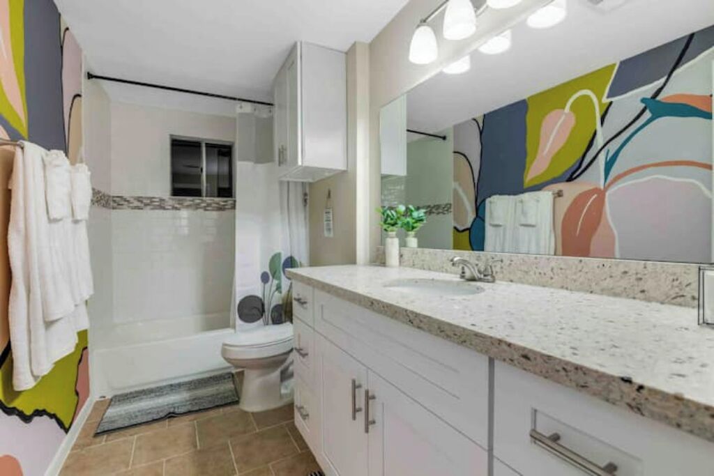Een moderne badkamer met douche, toilet en wastafel.