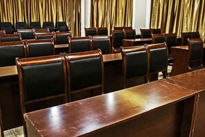 A conference room with rows of wooden tables and black chairs. - Haotai City Hotel (Jingzhou Renxinhui) (Jingzhou)