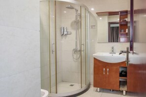 A modern bathroom with a glass-enclosed shower, a white sink, and a wooden vanity. - Haotai City Hotel (Jingzhou Renxinhui) (Jingzhou)