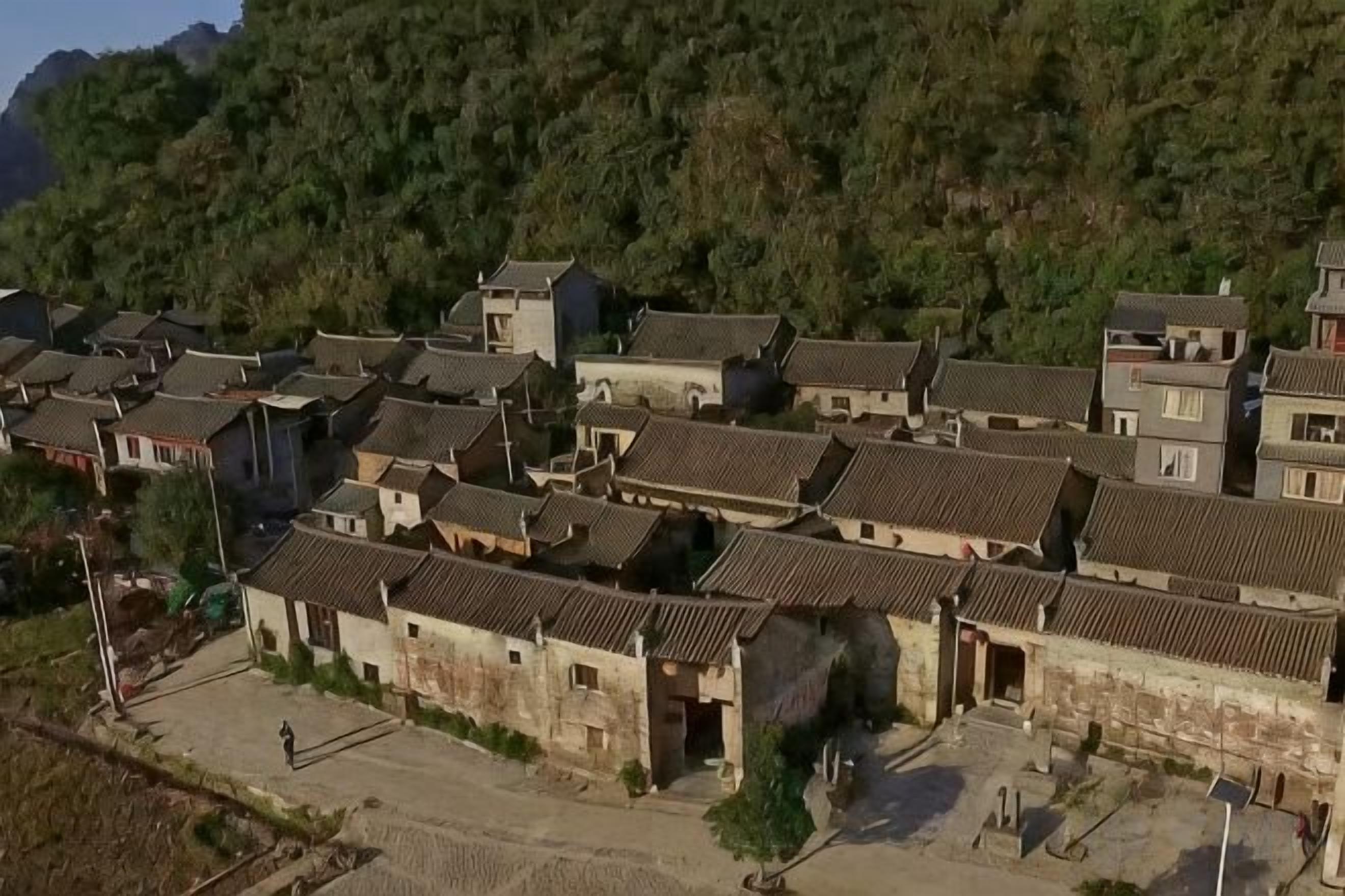 Un pueblo tradicional con edificios muy juntos, calles estrechas y un paisaje montañoso al fondo.