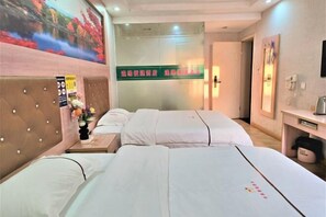 A hotel room with two beds, a wooden headboard, a nightstand with a vase of flowers, a wall-mounted clock, and a painting of a landscape. - Nanning Fengyuan Convenient Hotel No. 1 Affiliated Hospital of Medical University (Nanning)
